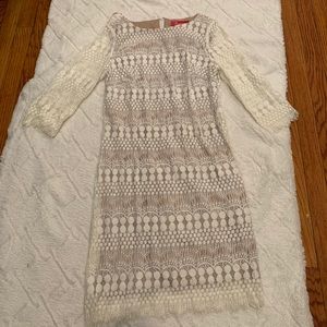 A mid length lace dress with mid leaning sleeves.